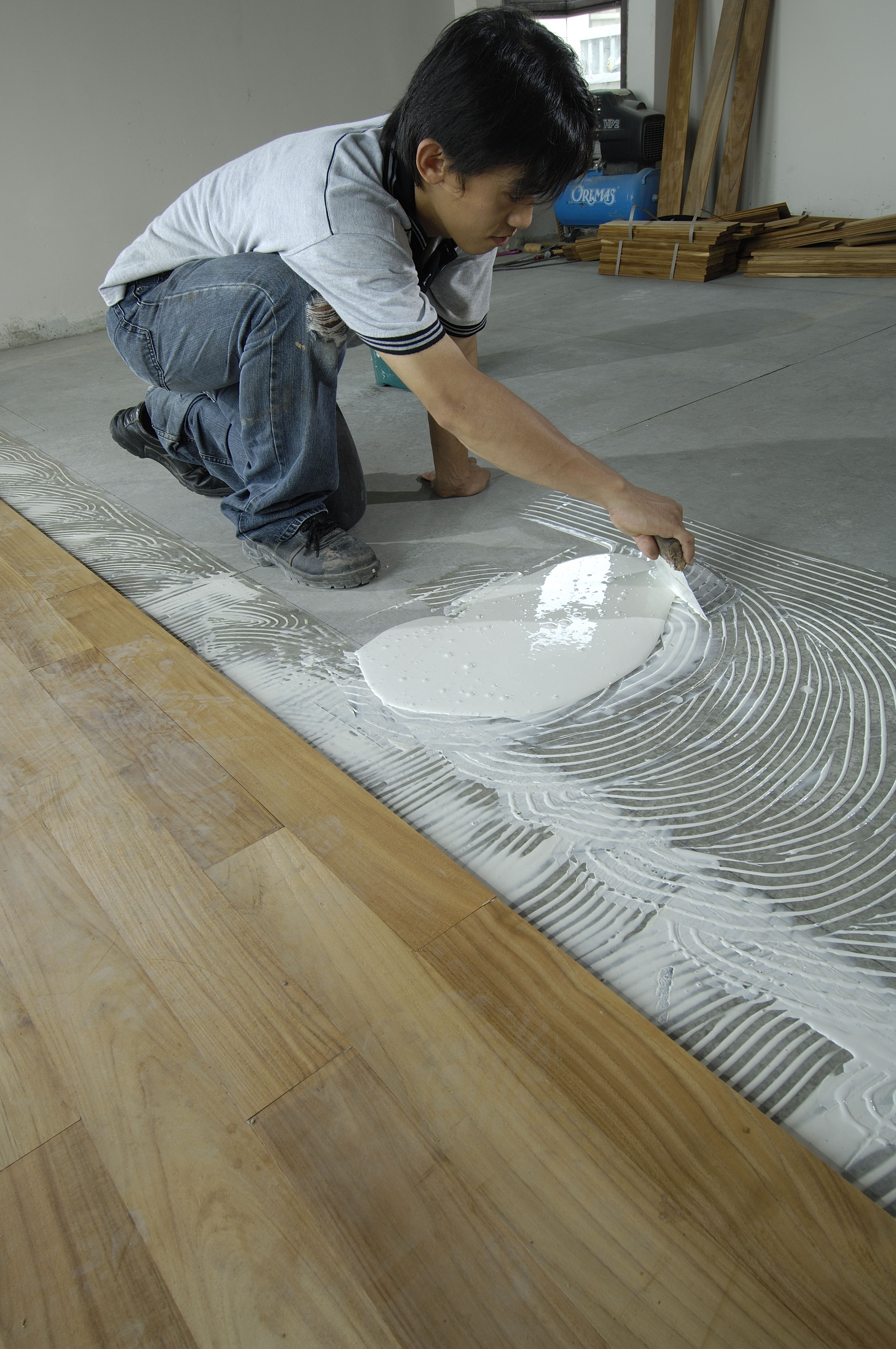 Step 2 – Laying Timber Strips: applying Megabond adhesive using a steel notched trowel